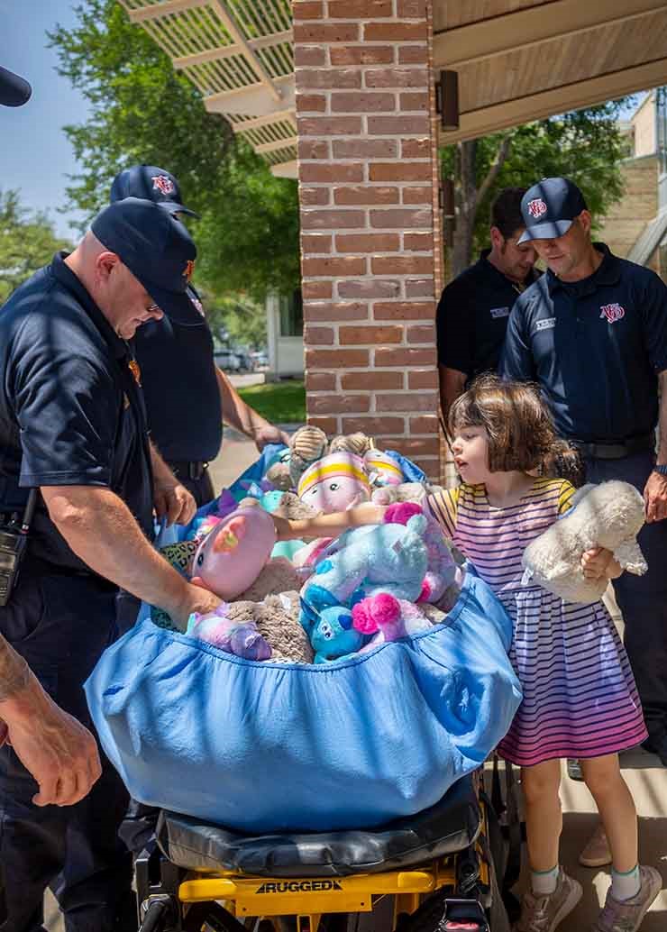 Preschool student donating stuffed animals