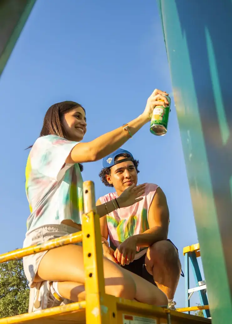 Two senior painting the Greenhill water tower