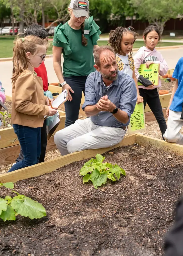 Teacher instructing students in the garden