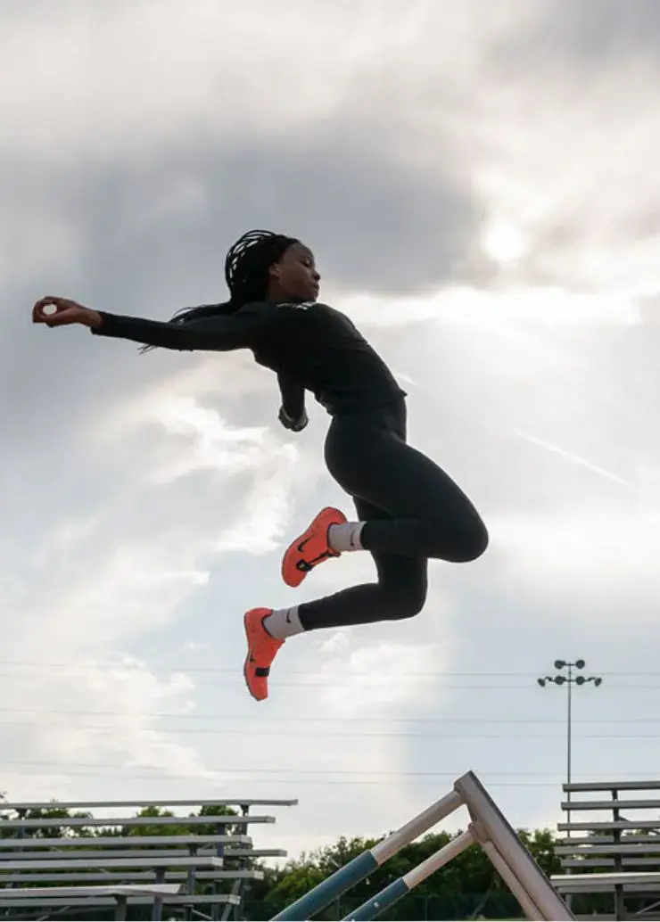 Student jumping over a hurdle